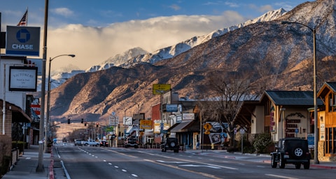 cars on road near brown mountain under blue sky during daytime
