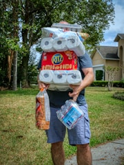 person holding white and red plastic pack