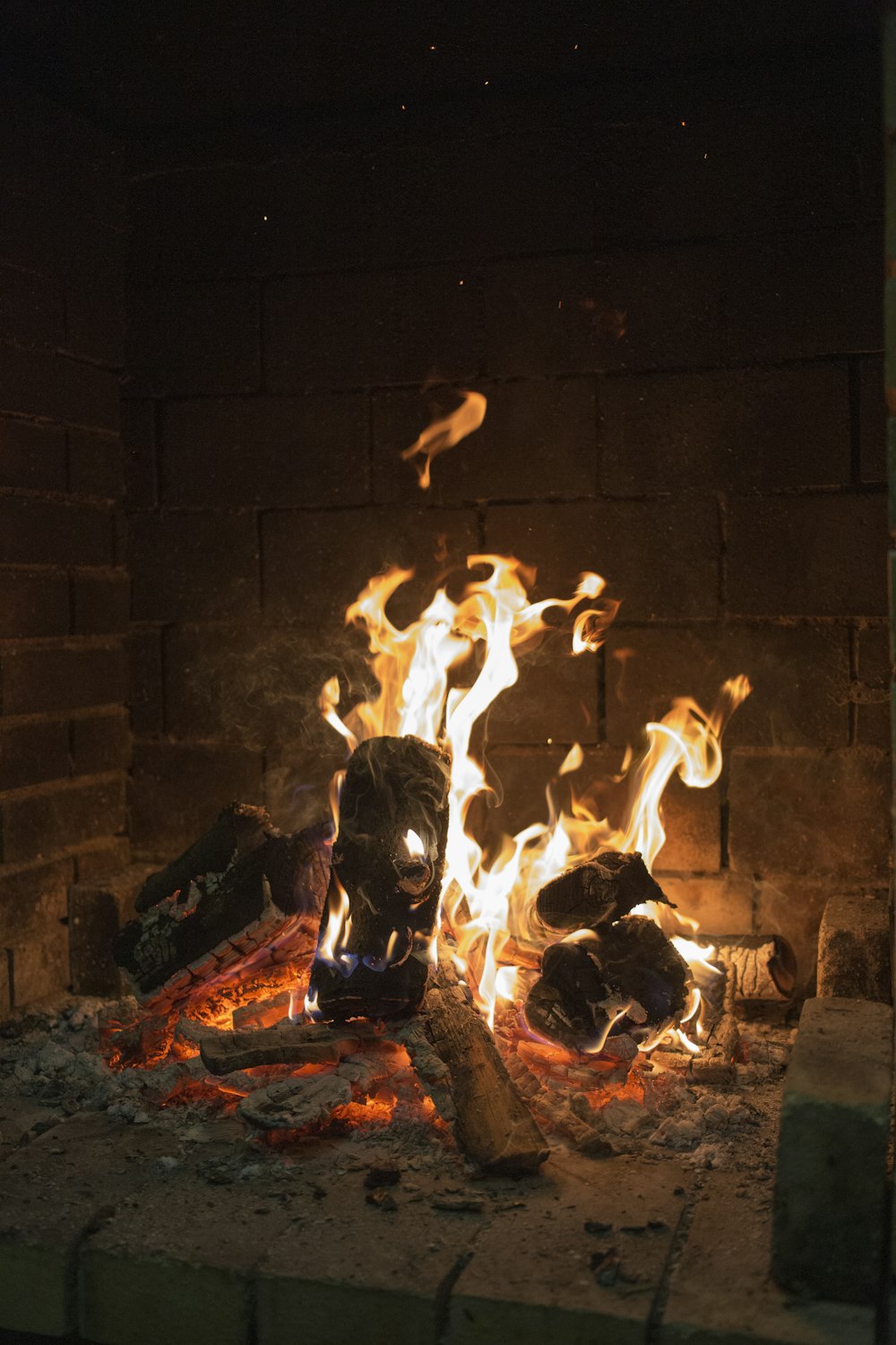 fire in front of brown brick wall