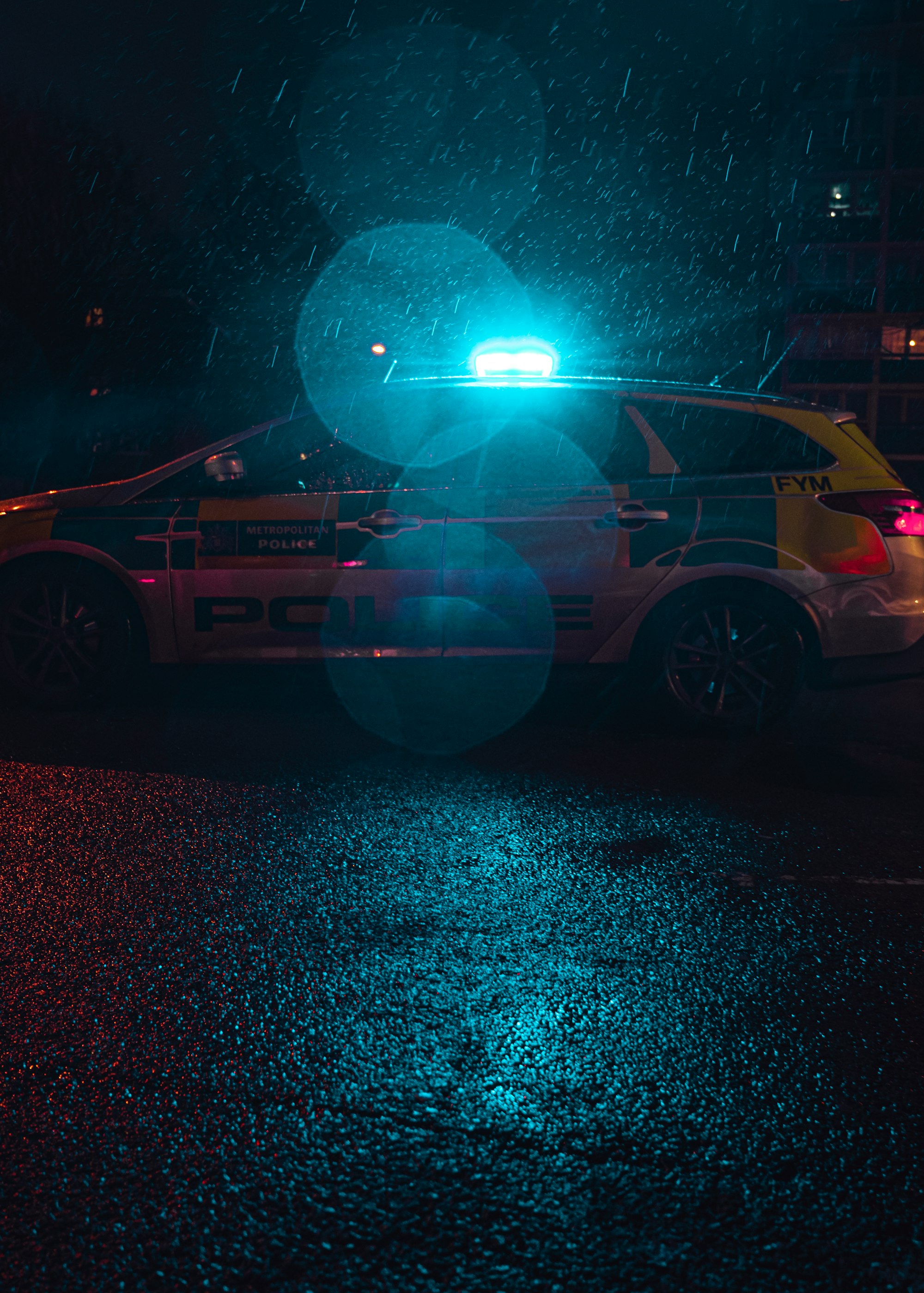 A parked police car is lit up by blue lights