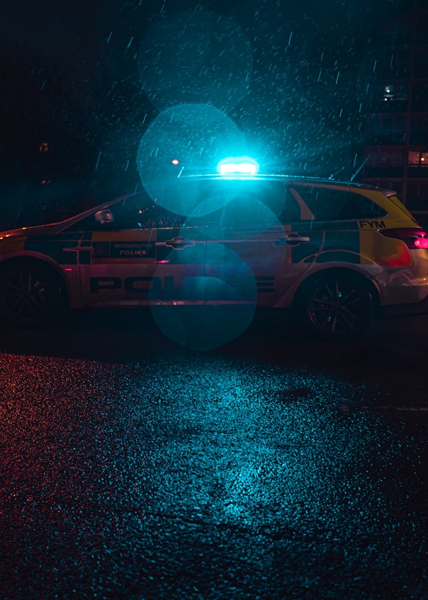 A parked police car is lit up by blue lights