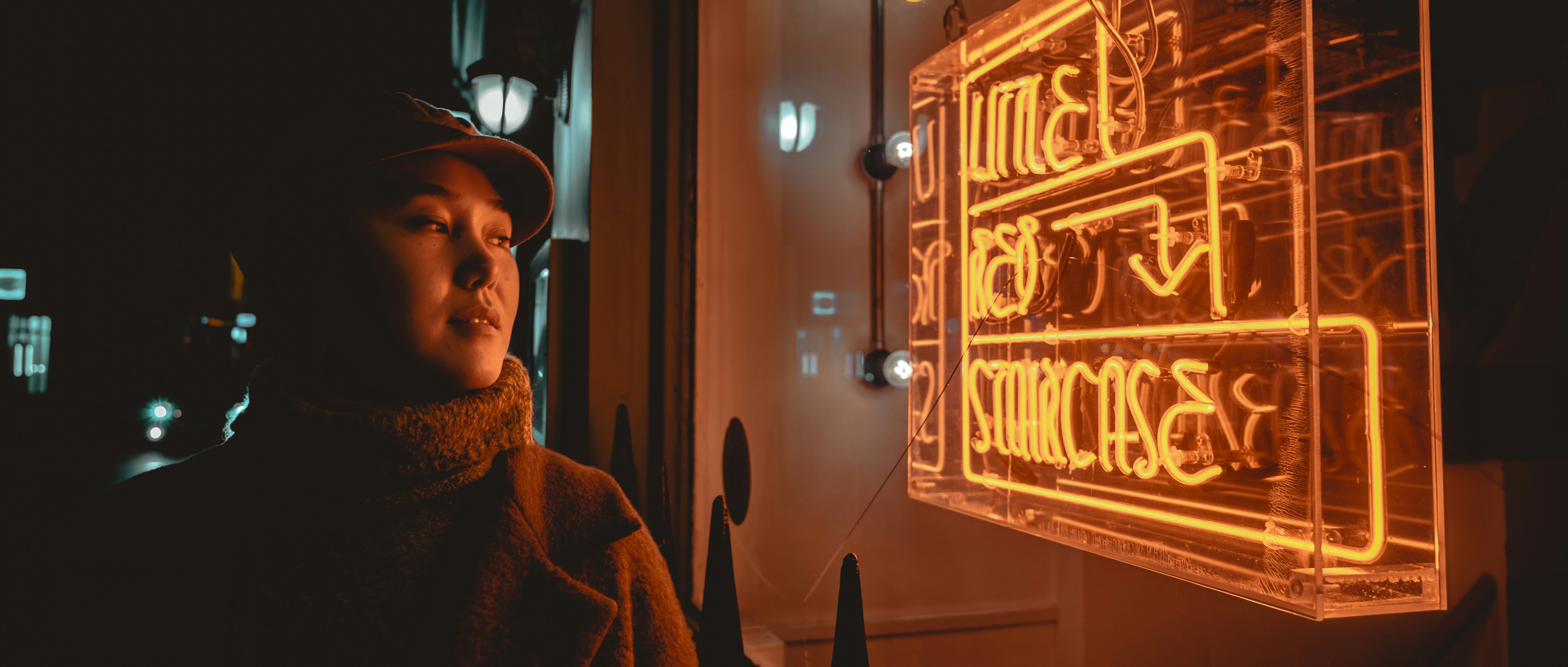man in brown coat standing near brown wooden door
