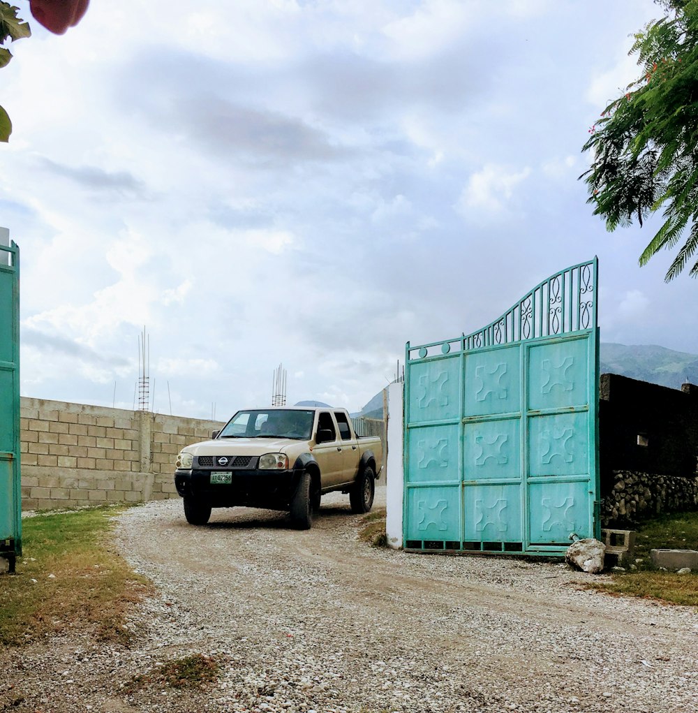 white car parked beside green building