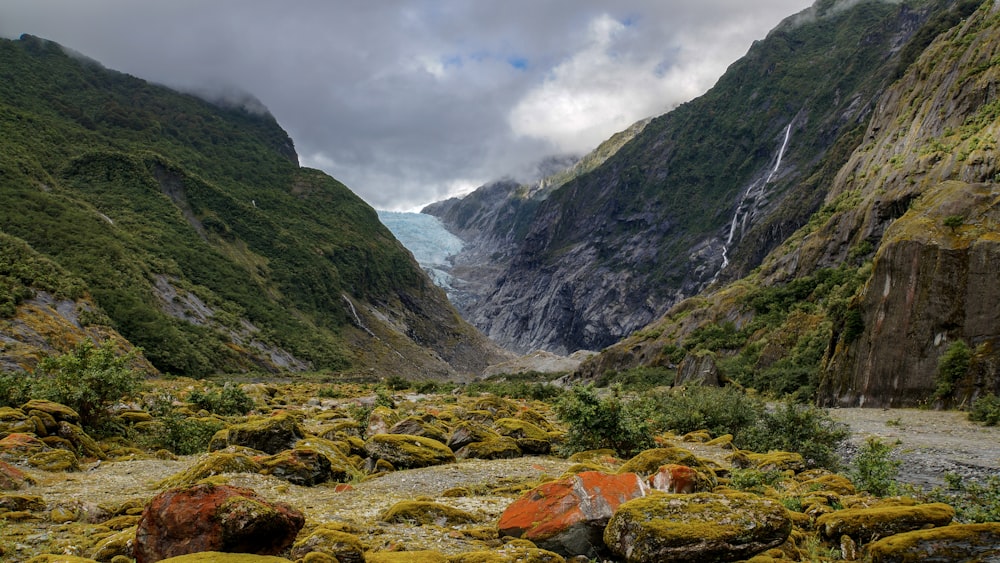 montañas verdes y grises bajo nubes blancas y cielo azul durante el día