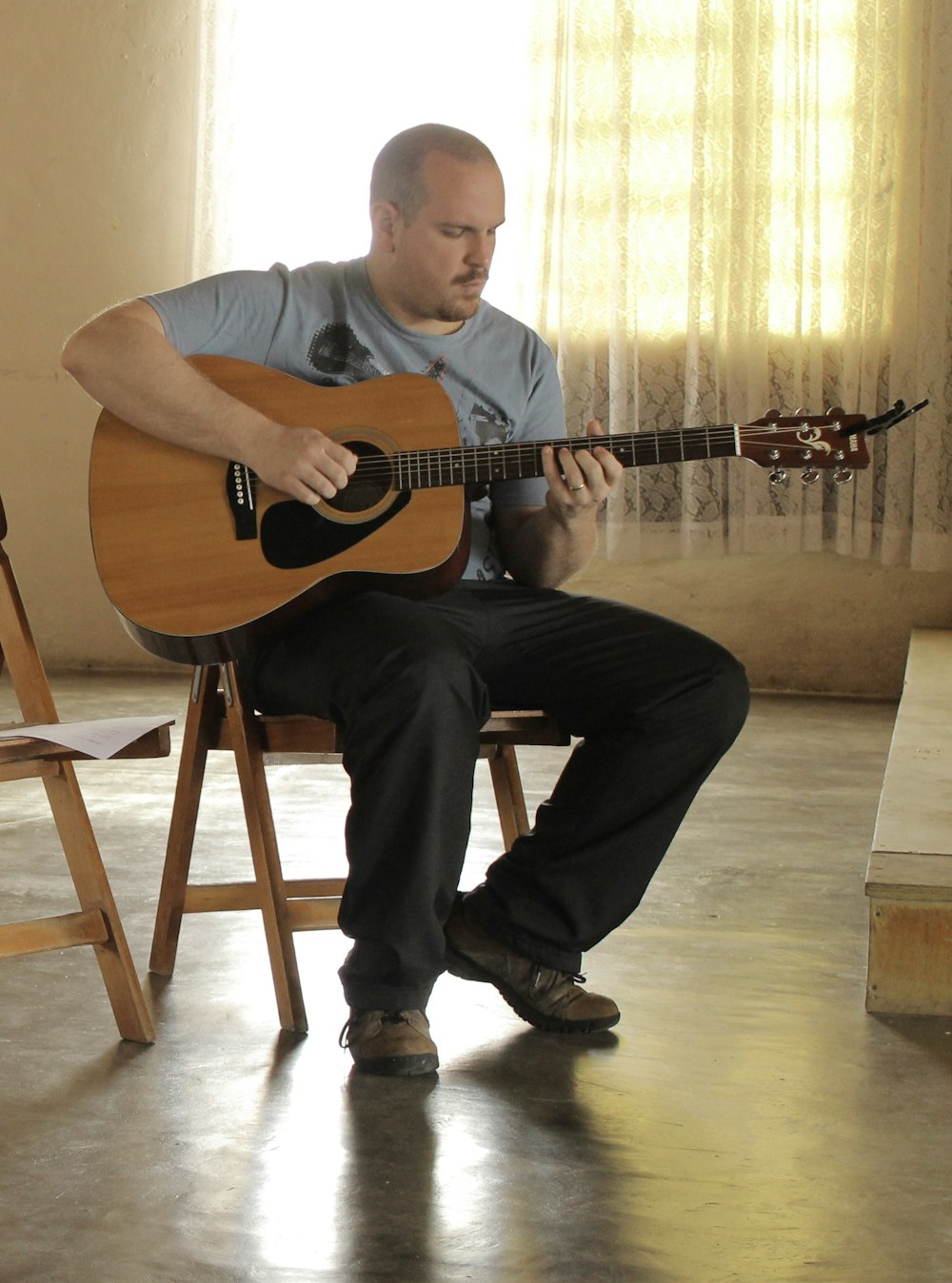 man in gray polo shirt playing brown acoustic guitar