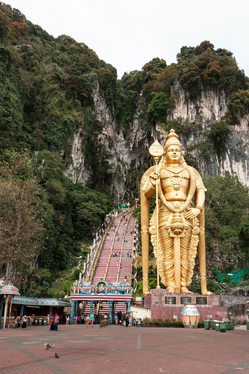 gold statue of man near body of water during daytime