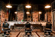 black leather barber chair near brown brick wall