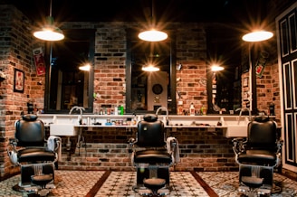 black leather barber chair near brown brick wall