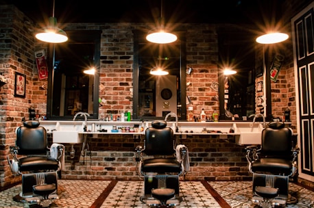 black leather barber chair near brown brick wall