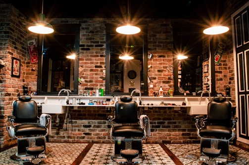 black leather barber chair near brown brick wall