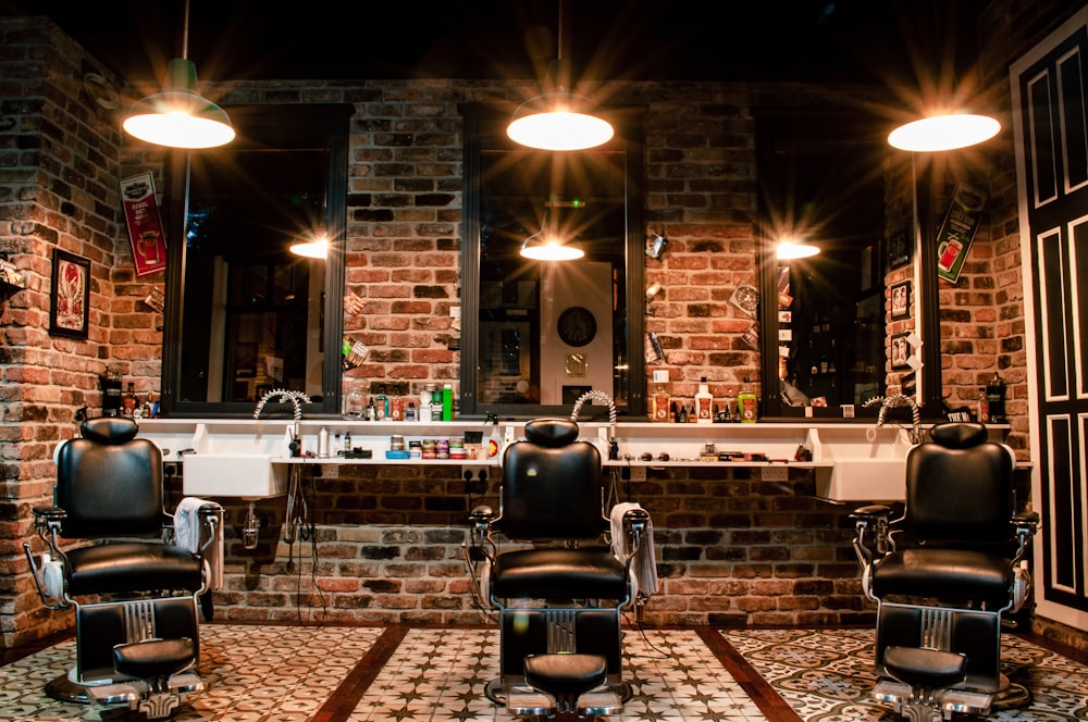 black leather barber chair near brown brick wall