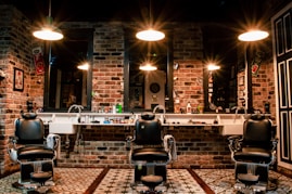 black leather barber chair near brown brick wall