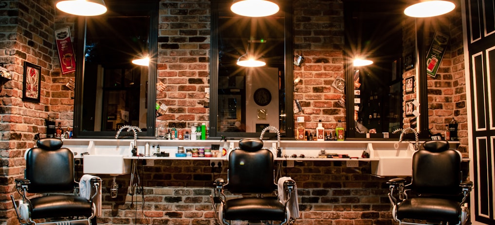 black leather barber chair near brown brick wall