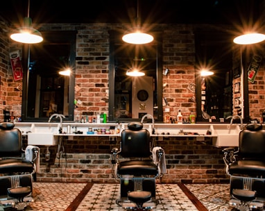 black leather barber chair near brown brick wall