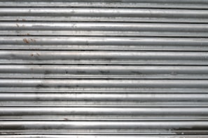 Side view of a metal rolling shutter freshly fixed, shining in daylight.