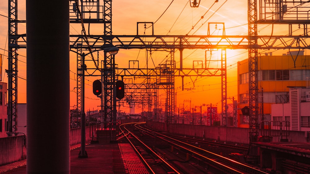 Ferrovia del treno vicino all'edificio rosso e giallo durante il tramonto