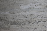Elegant slab of quartzite with a swirling blend of charcoal and white tones against a minimalist backdrop.