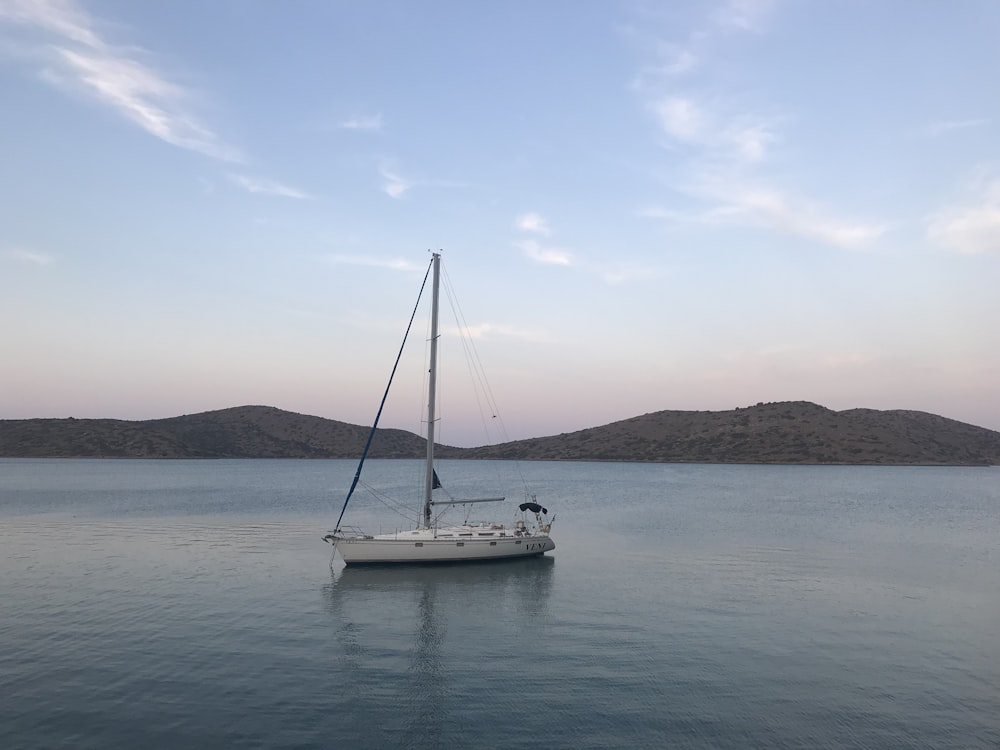 white sail boat on sea during daytime