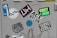 A collection of colorful stickers on a light gray surface, including a blue abstract face with eyes on one sticker, and various text-based designs featuring words like 'UGLYHOUSE', 'GREY JAM', and 'JOBZY'. Some stickers display bold typography, while others are artistic or illustrative.