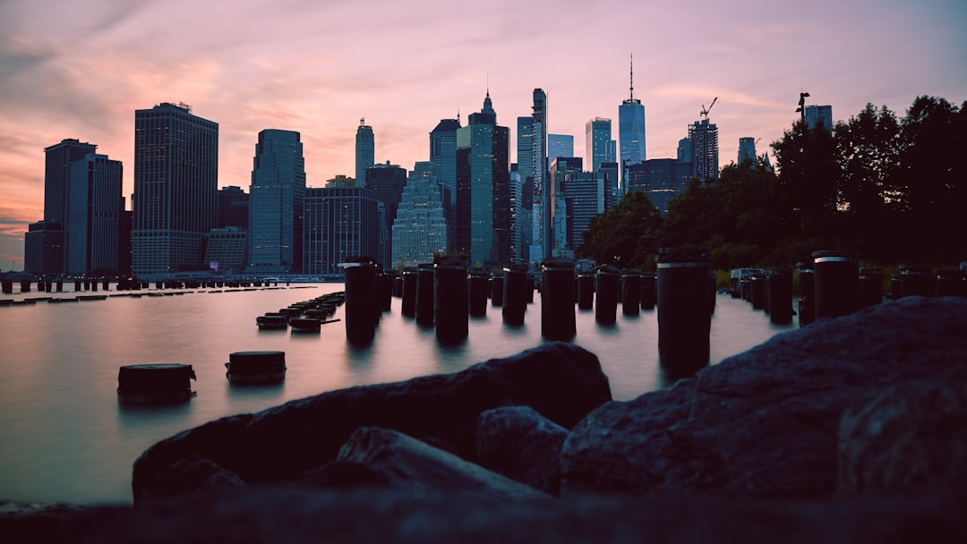 city skyline across body of water during night time