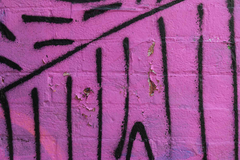 pink and black graffiti on wall