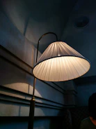 A softly lit corner showcasing a unique lamp casting gentle shadows on a cream wall.