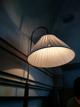 A softly lit corner showcasing a unique lamp casting gentle shadows on a cream wall.