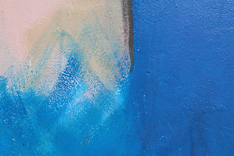 A vibrant wall painted with a textured blue finish in a cozy living room.