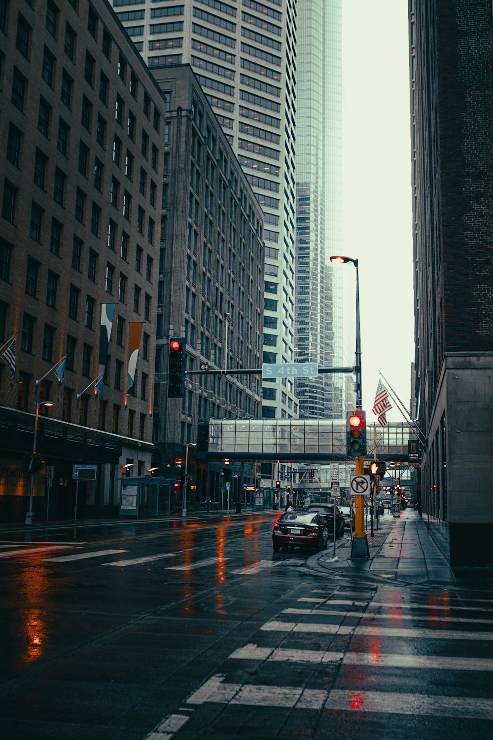 cars on road in between high rise buildings during daytime