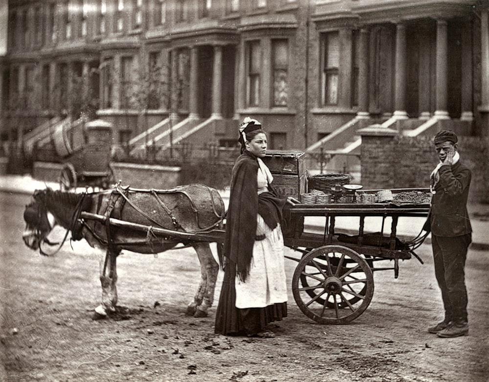 grayscale photo of man riding horse carriage