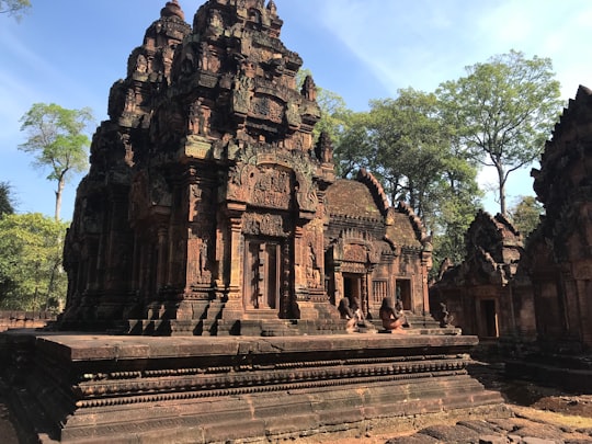 brown concrete building near green trees during daytime in Banteay Srei Cambodia