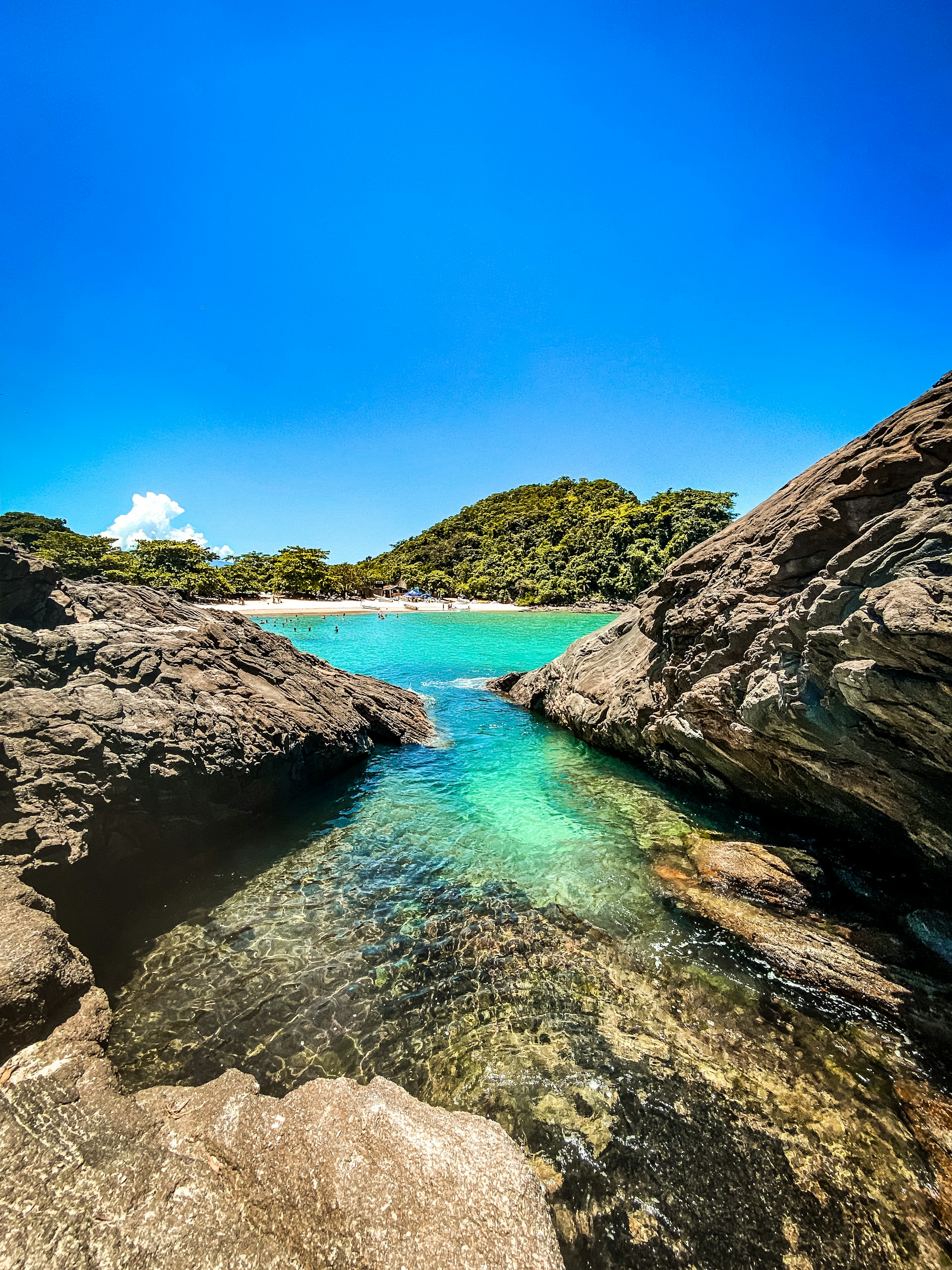body of water between brown and green mountains under blue sky during daytime
