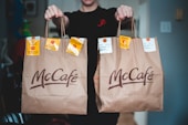 person holding white and brown tote bags