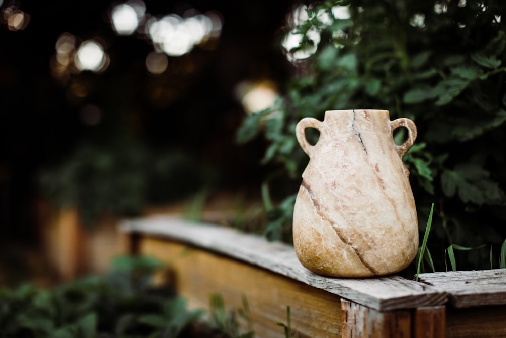 vaso de cerâmica branco na mesa de madeira marrom