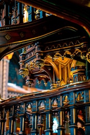 Elaborate and ornate architectural details featuring intricate woodwork and decorative patterns. The design is characterized by prominent arches and scrollwork, highlighting a mix of gothic and baroque styles with rich embellishments.