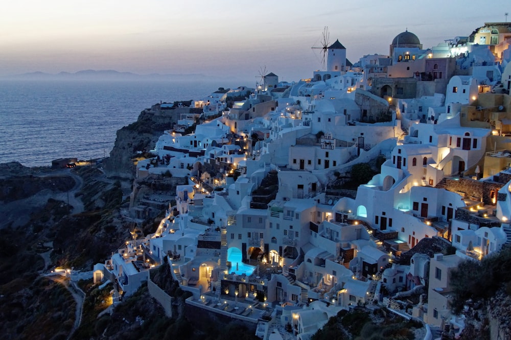 white and brown houses on top of mountain near body of water during daytime