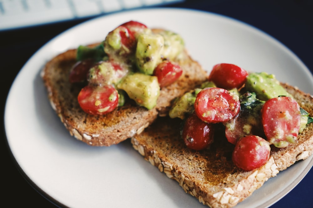 Pain à la tomate et aux légumes verts sur assiette en céramique blanche