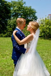 A serene pre-wedding couple embracing in a sunlit park with vibrant greenery.