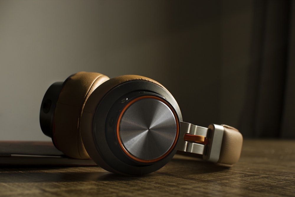 white and black headphones on brown wooden table