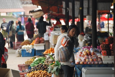 A lively market scene with local vendors selling fresh fruits and traditional snacks.
