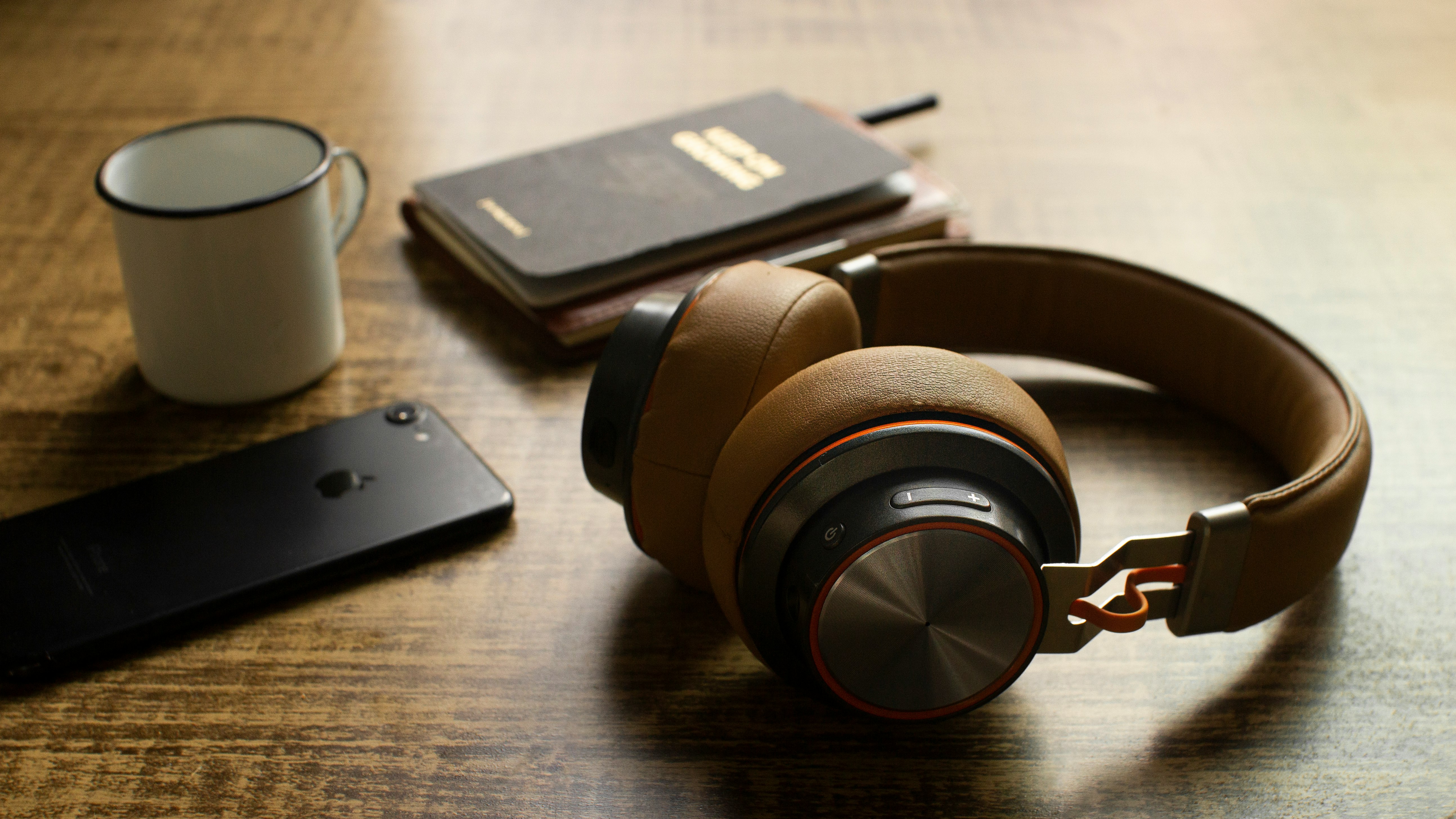 black and brown headphones on brown wooden table