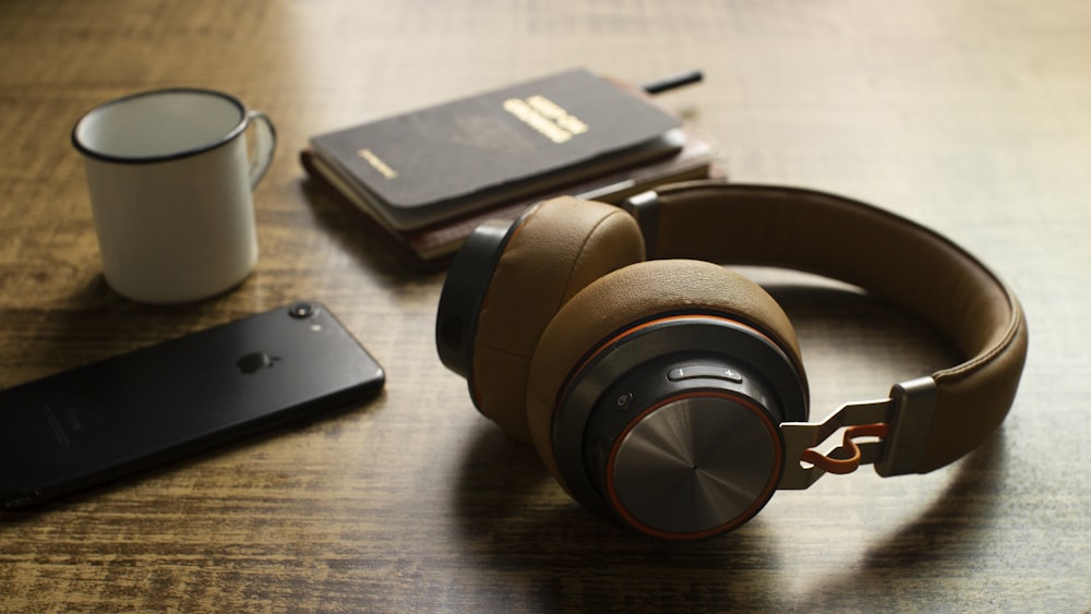 black and brown headphones on brown wooden table