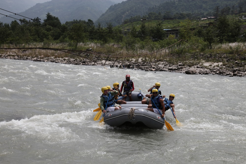 people riding on white and blue inflatable boat on river during daytime