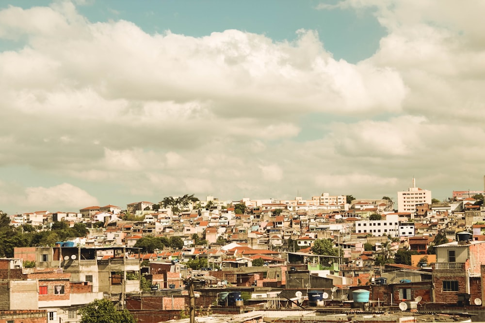 city buildings under white clouds and blue sky during daytime