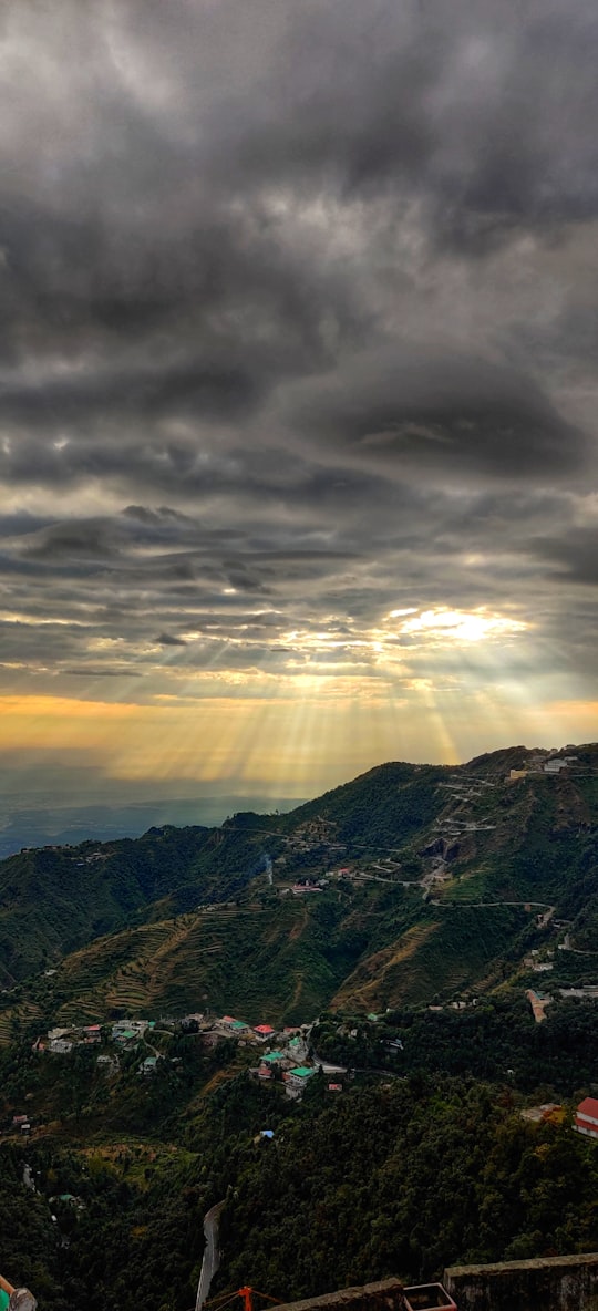green and brown mountains under white clouds during daytime in Mussoorie India