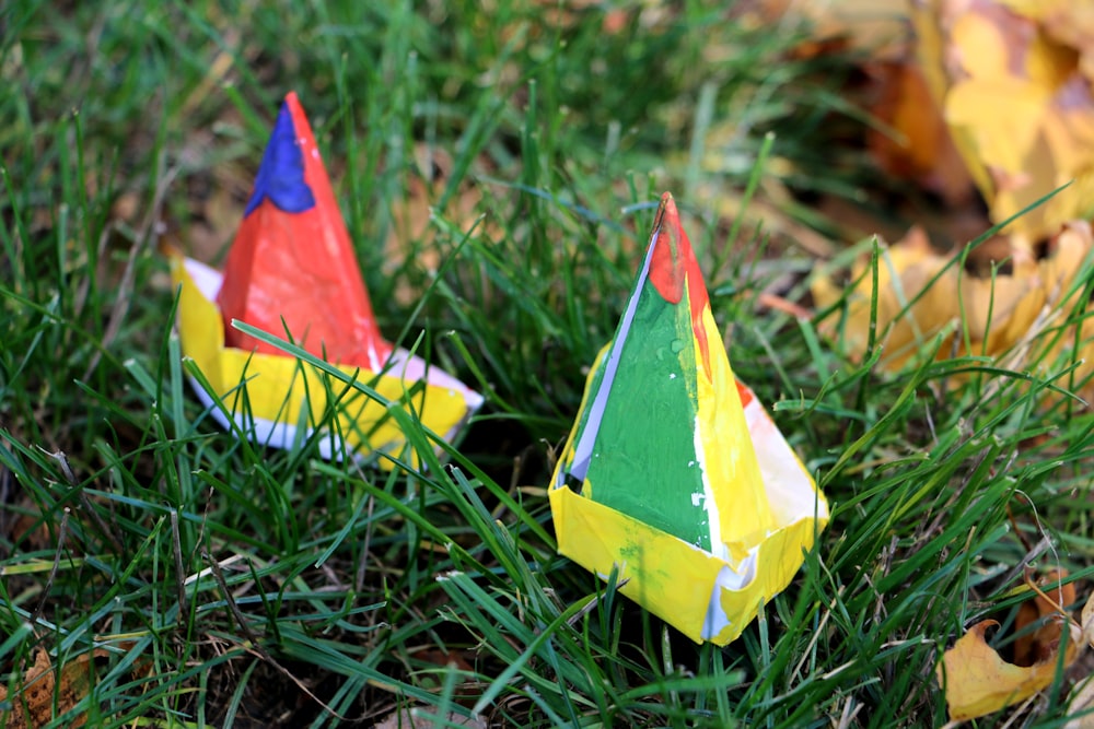 yellow red and green paper boat on green grass