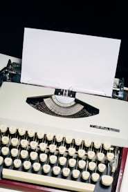 white and black typewriter on white table