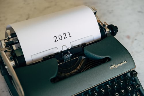 A forest green typewriter with a centered 2021 on the page