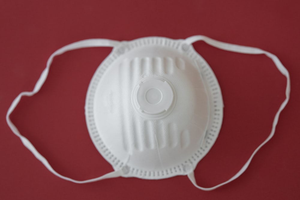 white round plastic lid on red textile