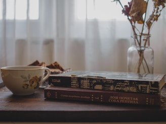 A cozy workspace with colorful beauty books and a cup of tea, inviting learning and relaxation.